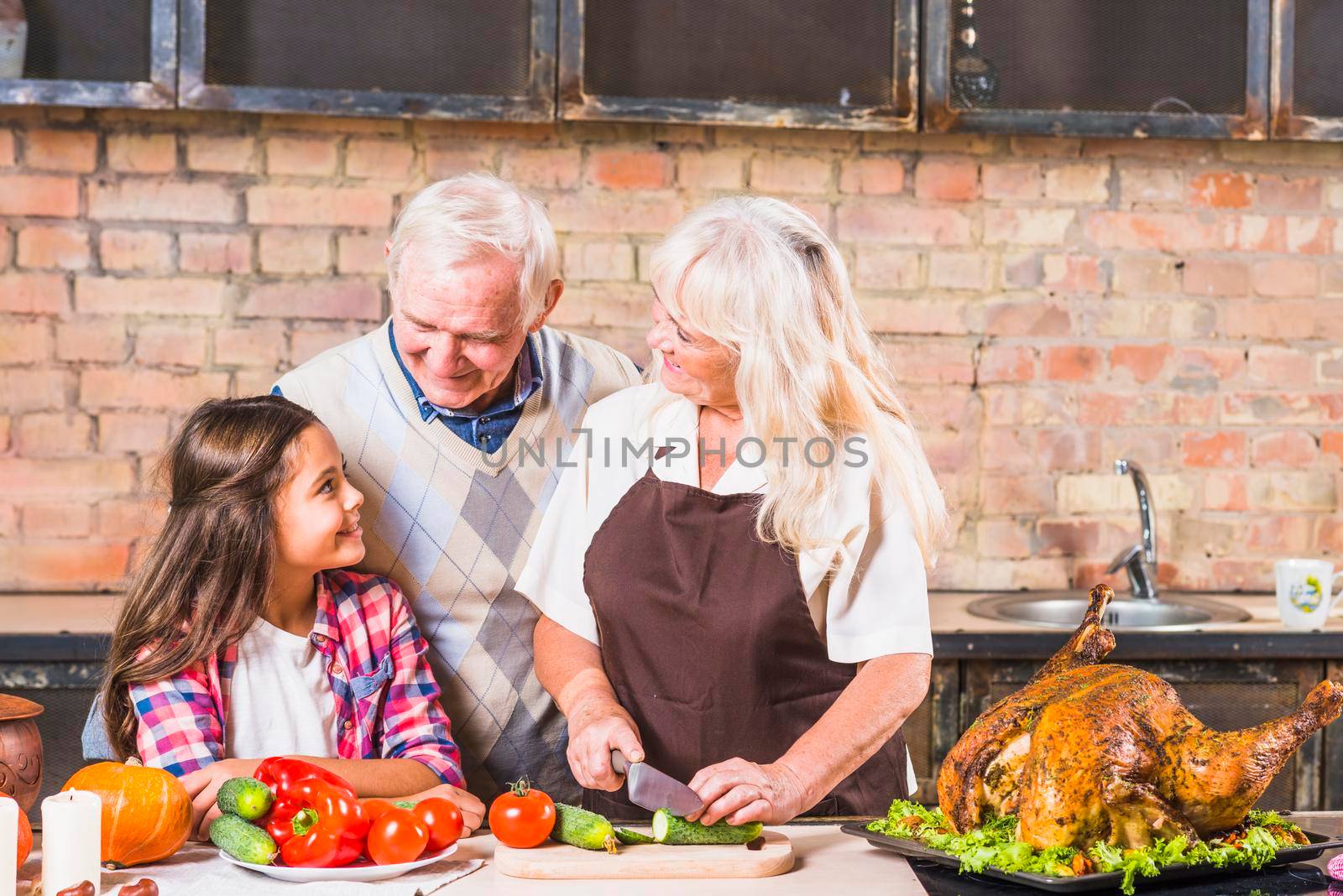 grandparents cooking turkey with granddaughter by Zahard