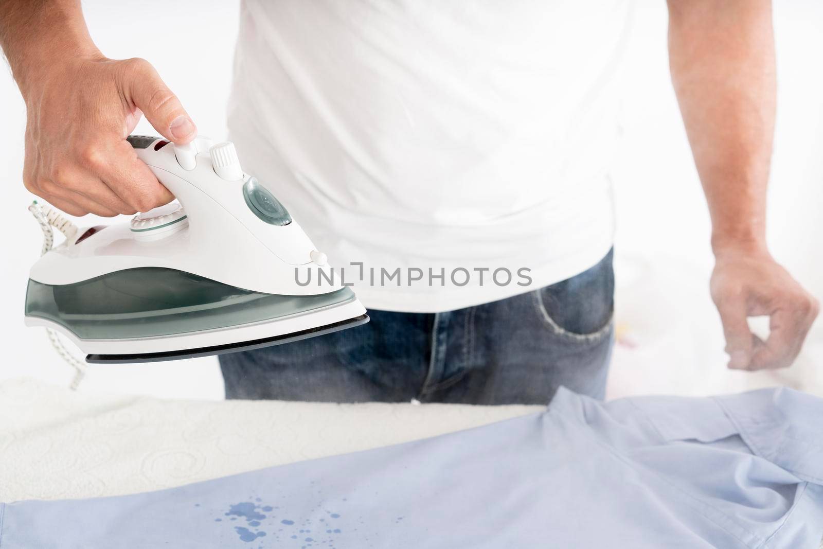 man steaming clothes with clothing iron by Zahard