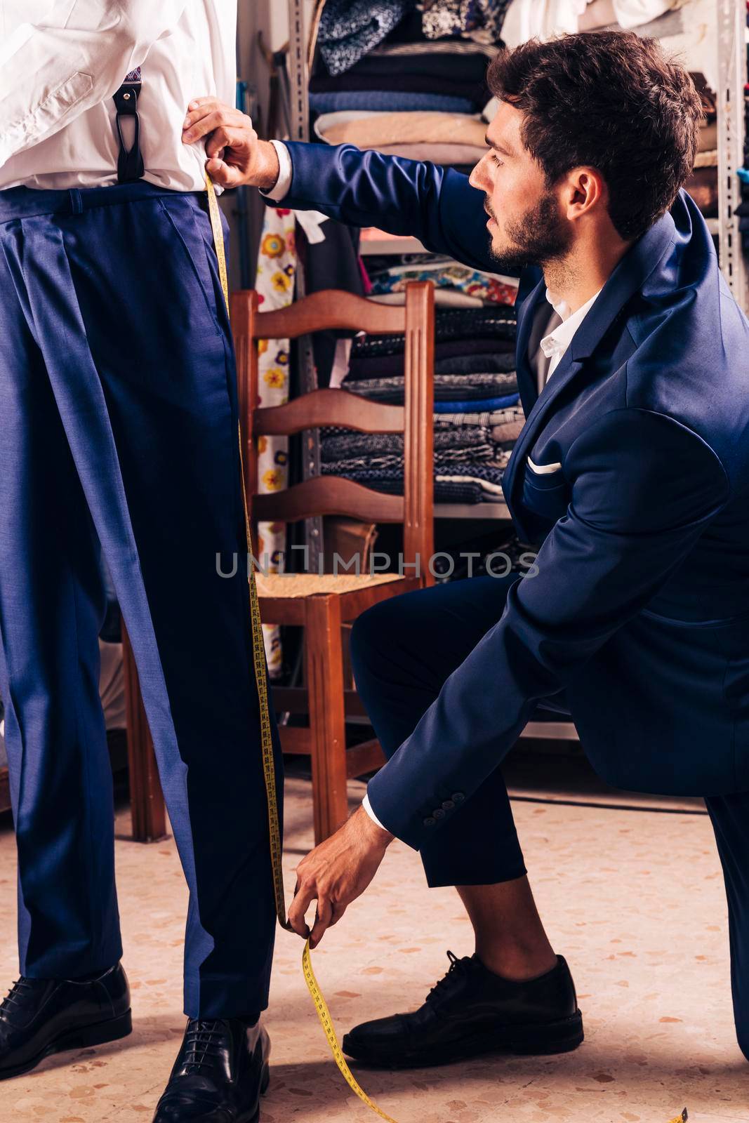 fashion designer taking measurement male customer s pant shop by Zahard