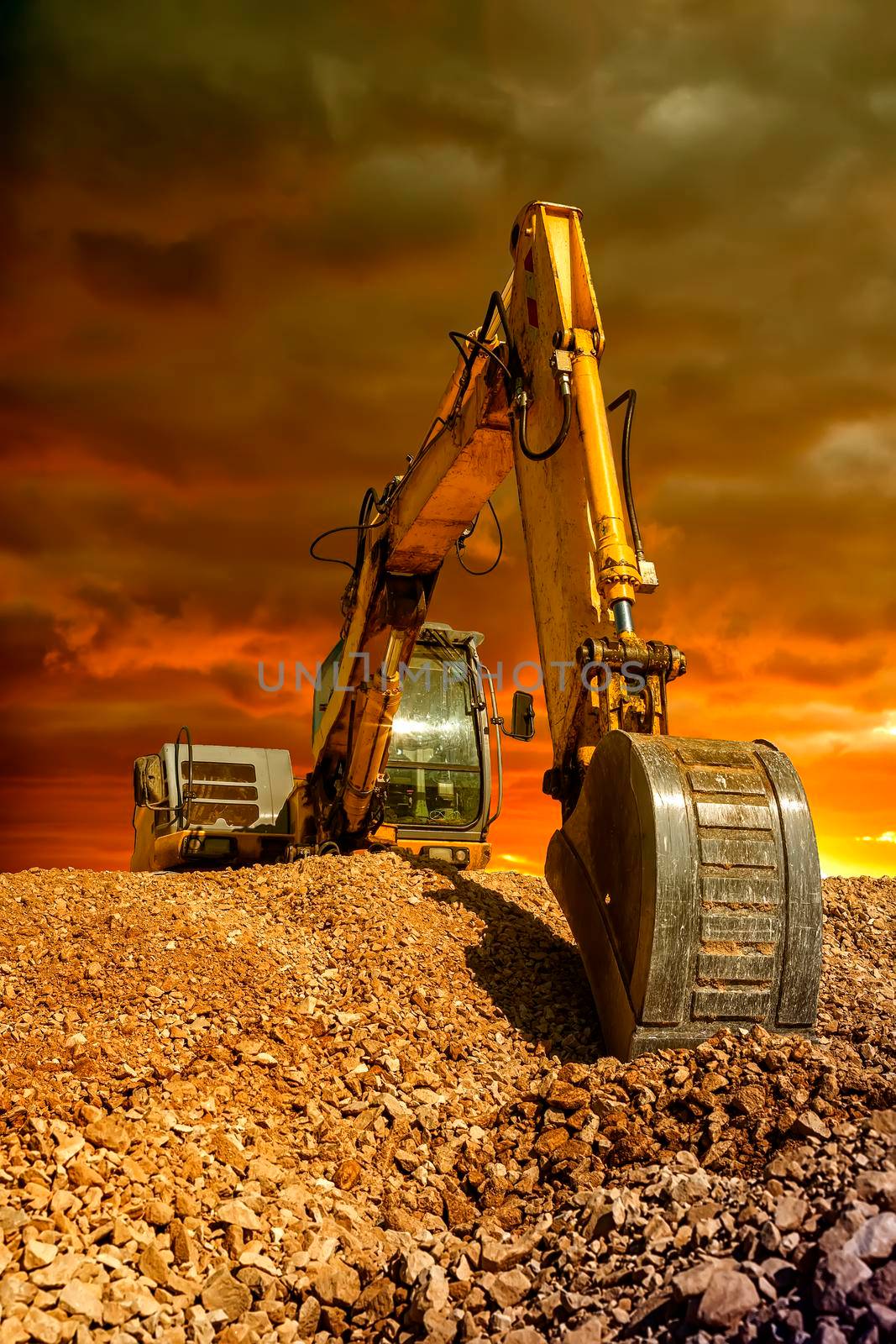 Stunning view at crawler excavator during earthmoving works on construction site at sunset by EdVal