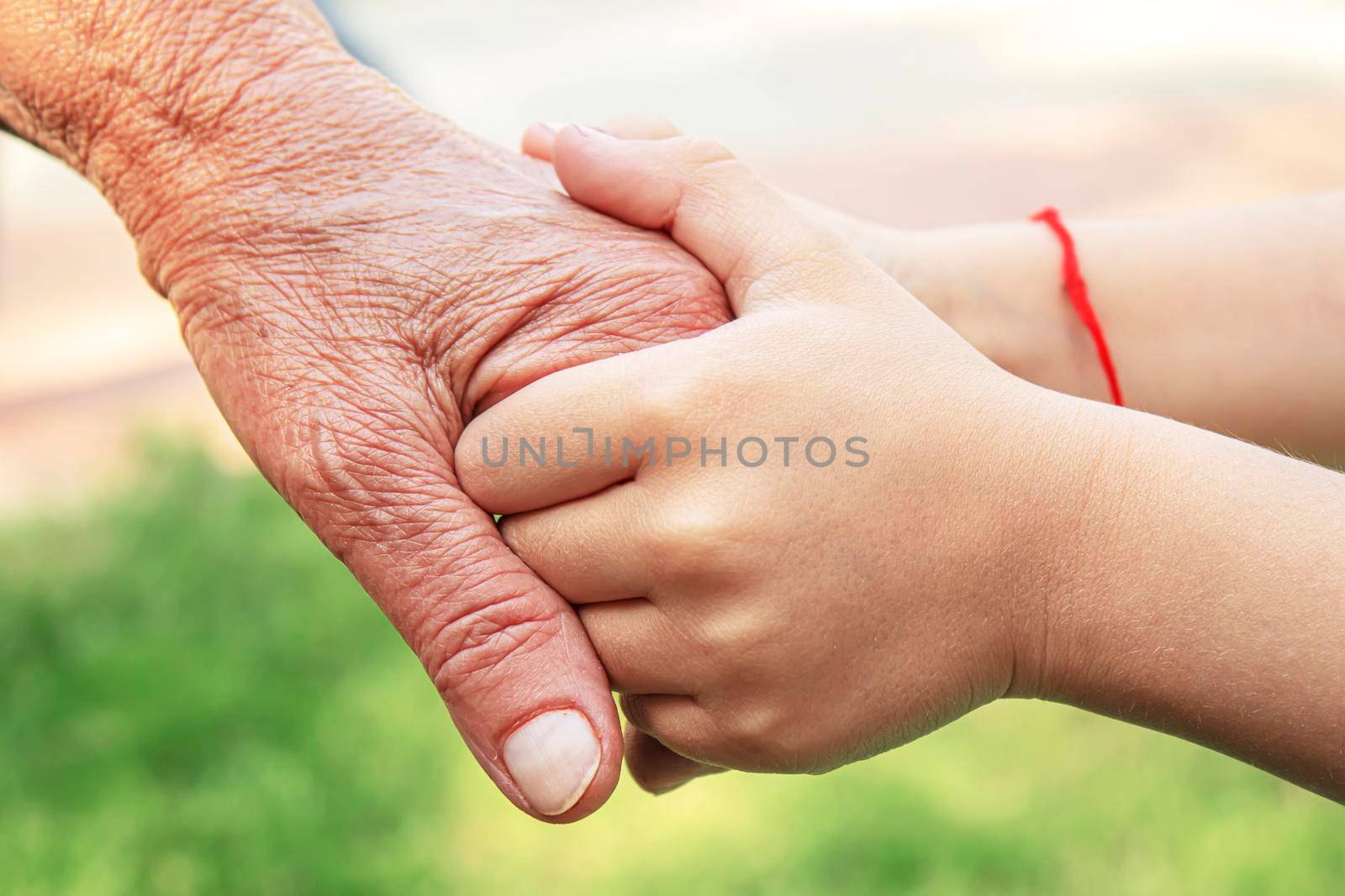 old man holding child's hands. selective focus people