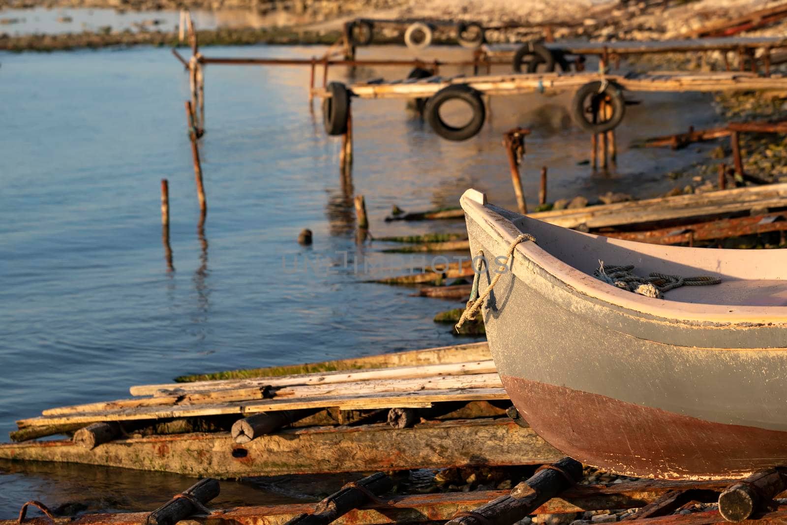 The tranquil afternoon on a seashore with a piers and boat