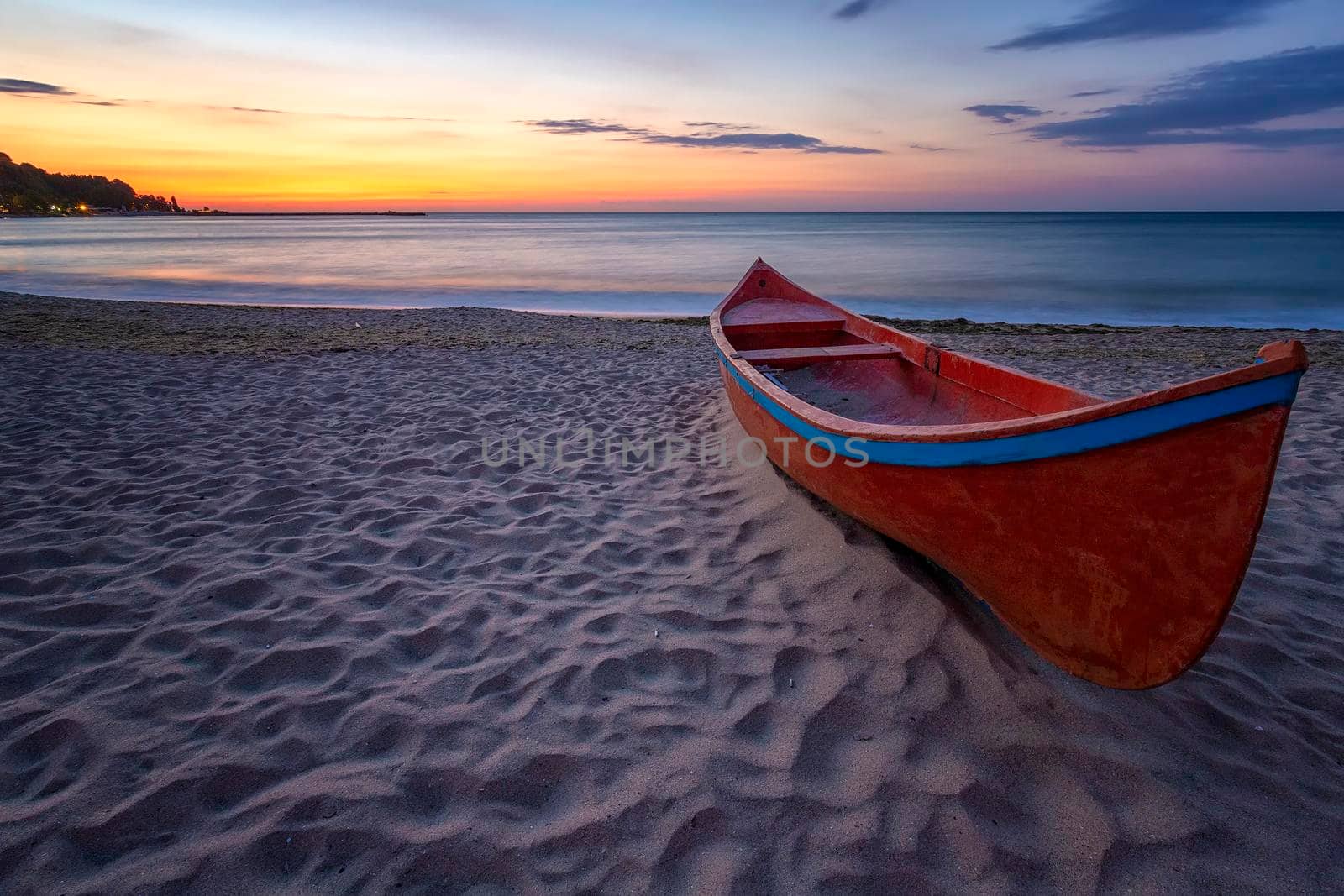 beauty morning with the lonely red boat on the sea beach 