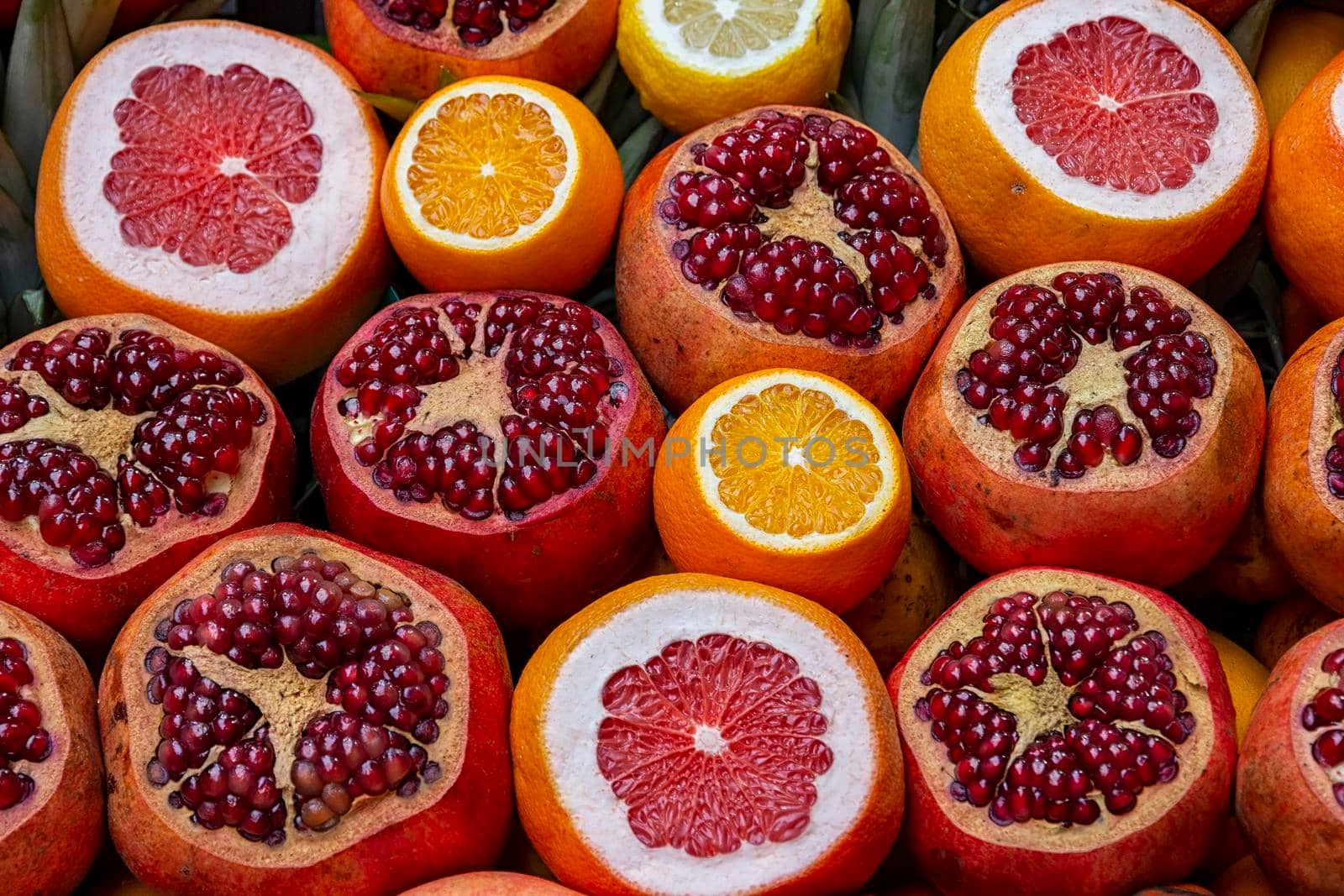 Many opened fruits at a market in Istanbul, Turkey during sunny day. Nice natural background with pomegranates, oranges and grape-fruits.