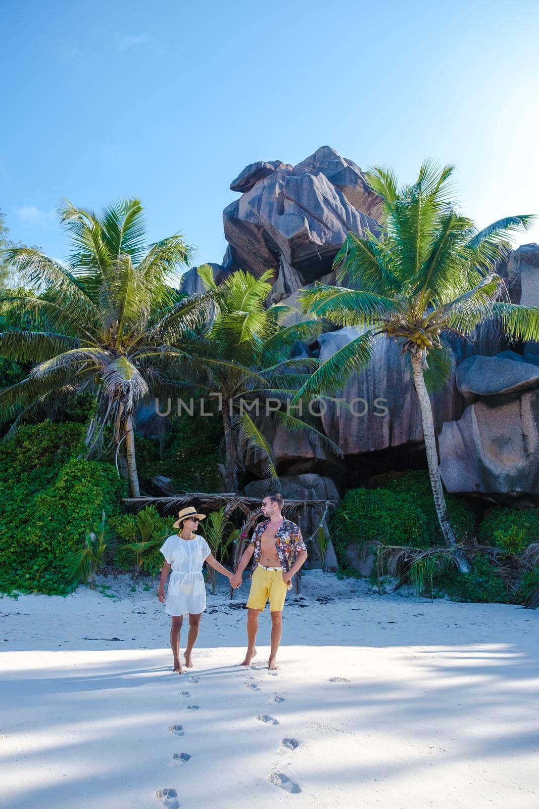 Anse Cocos beach, La Digue Island, Seyshelles, Drone aerial view of La Digue Seychelles bird eye view, couple men and woman walking at the beach during sunset at a luxury vacation by fokkebok