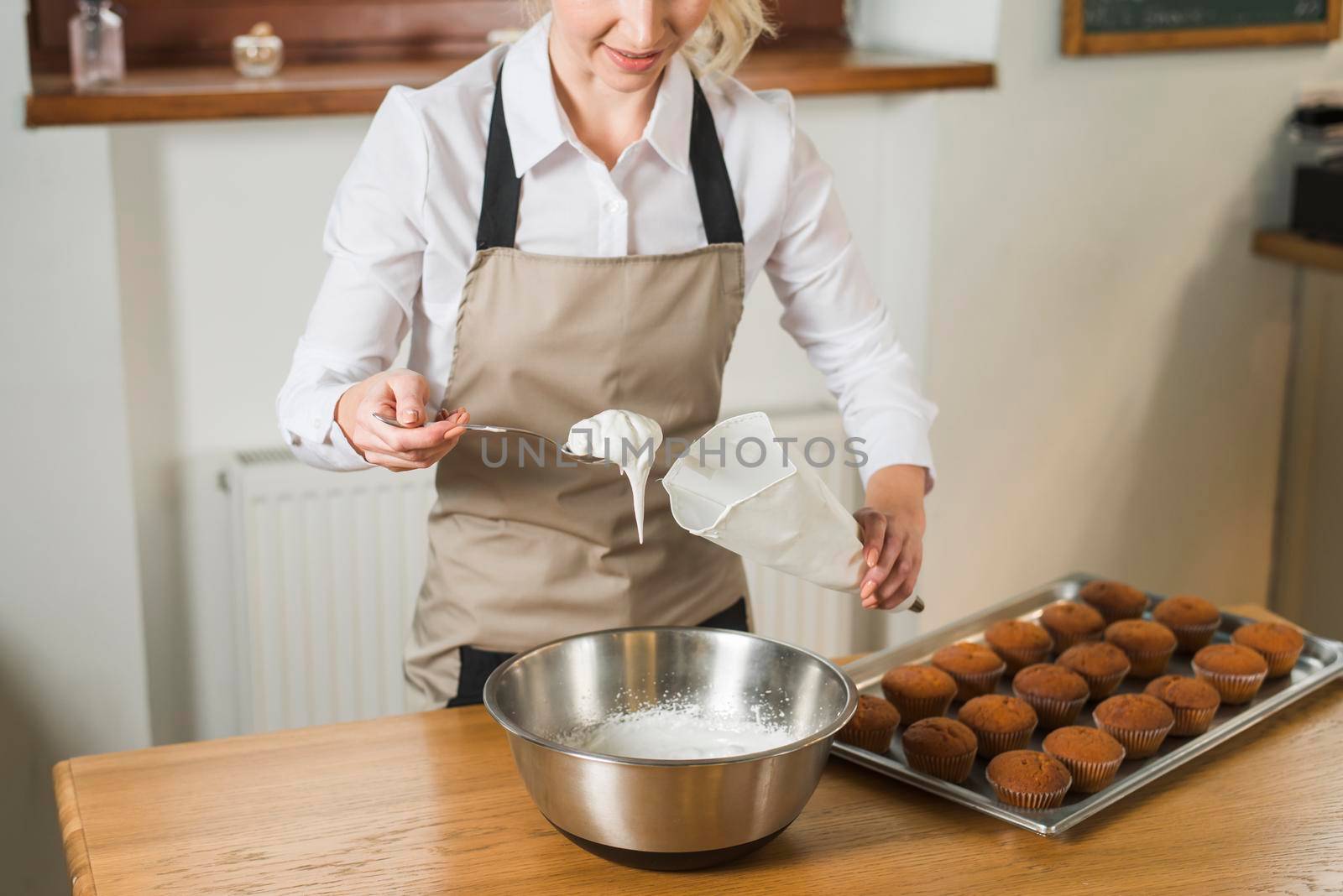 close up young woman putting white cream pastry bag