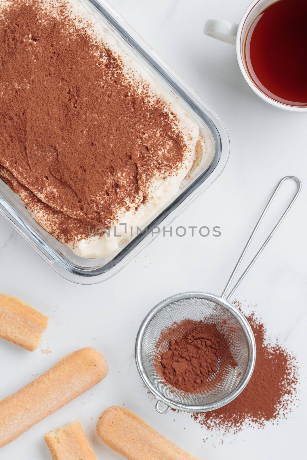 Homemade Tiramisu cake dessert on a white marble background by Gudzar