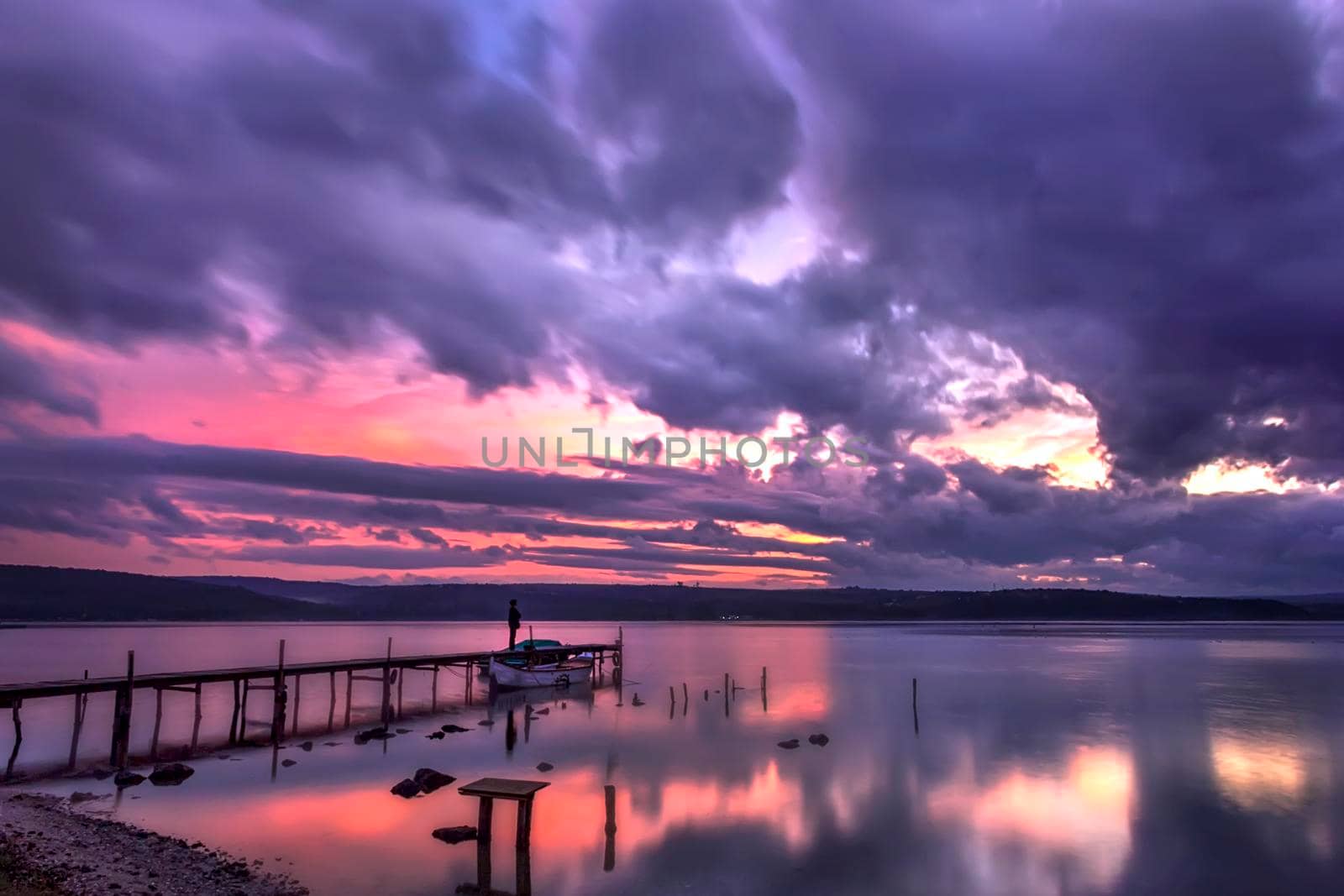 Mood and tranquility at a lake coast with the boat at a wooden pier