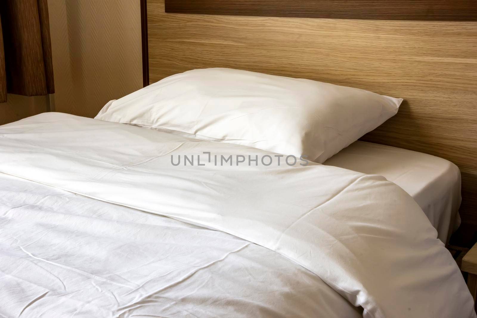 Soft pillow on a comfortable wood bed. Bedroom Interior.