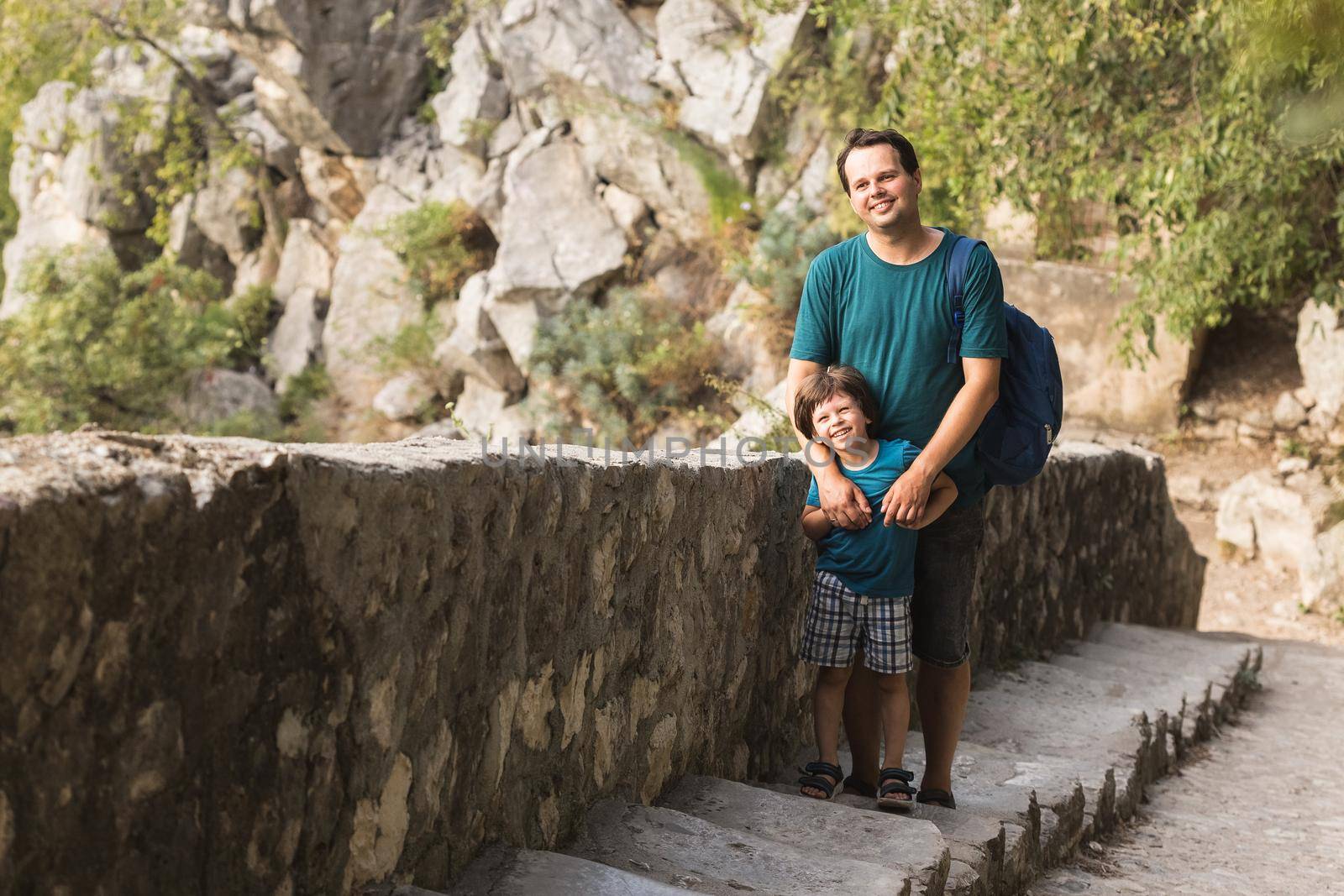 Father and his little son climbing the stairs on the ruins of St. John fortress in the in the Kotor Bay in Montenegro.
