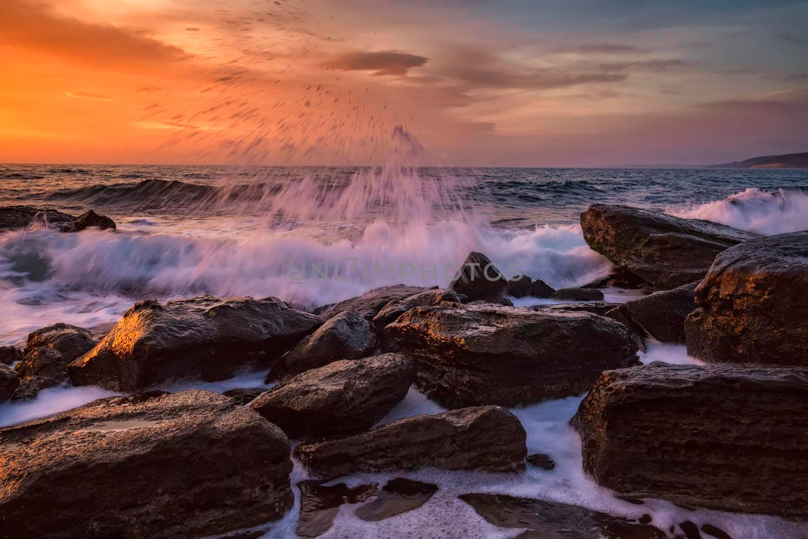 Amazing splash of seawater at morning on the shore of the Black Sea. Beautiful motion blur sea waves over the rocks. 