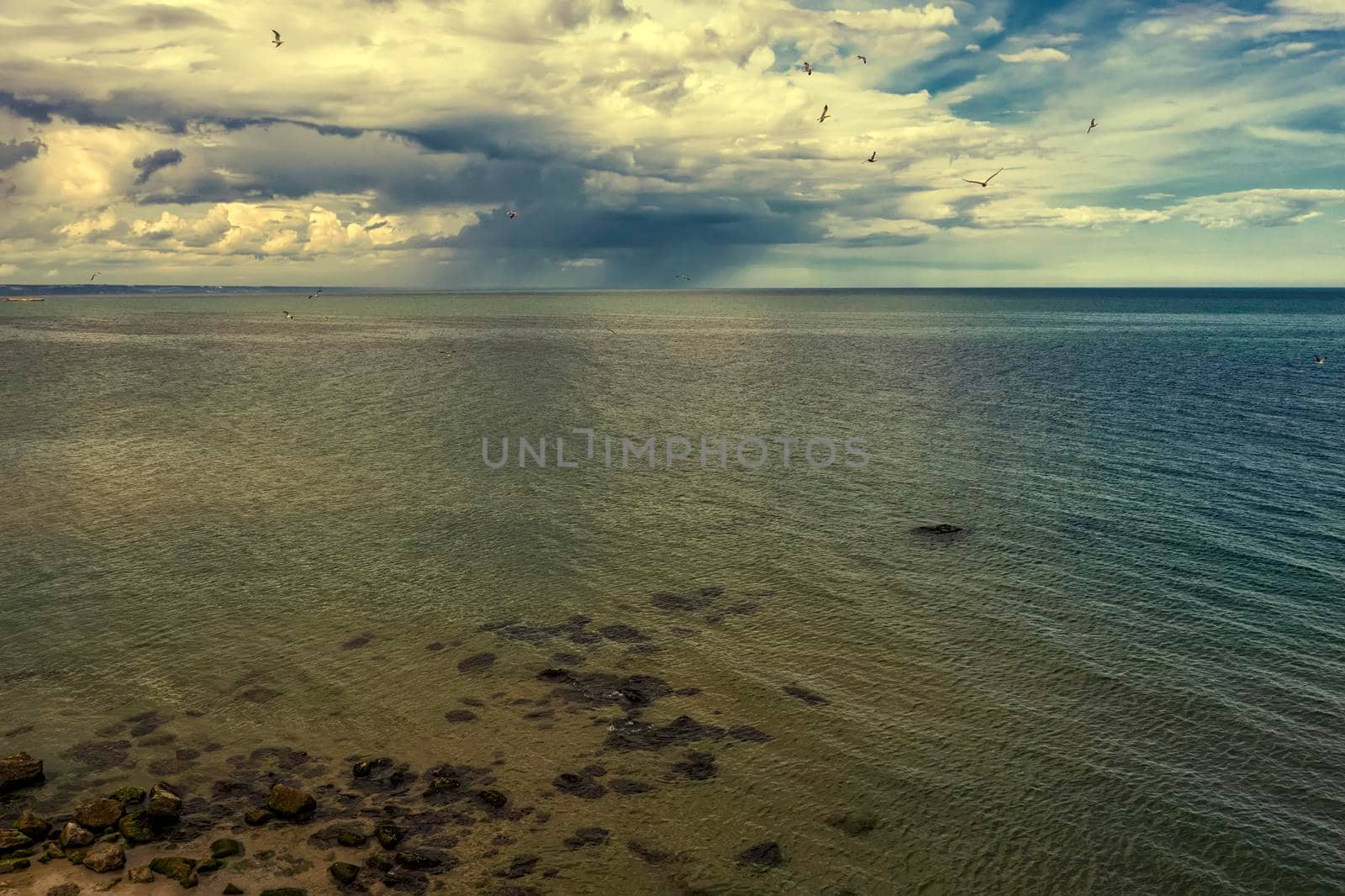 Aerial drone seascape of crystal clear lagoon sea water surface with rocks and cloudy sky