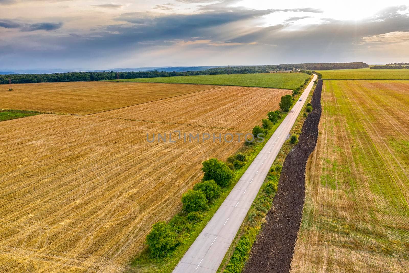 aerial view of a rural landscape with a farm road, wheat fields after harvest.