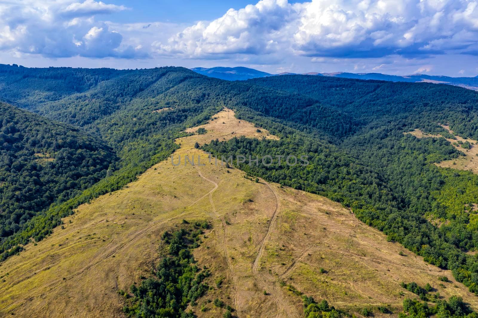 Panoramic Drone Aerial View view of mountain peaks. Hilltops covered with forest. Green nature background aerial view mountain landscape.