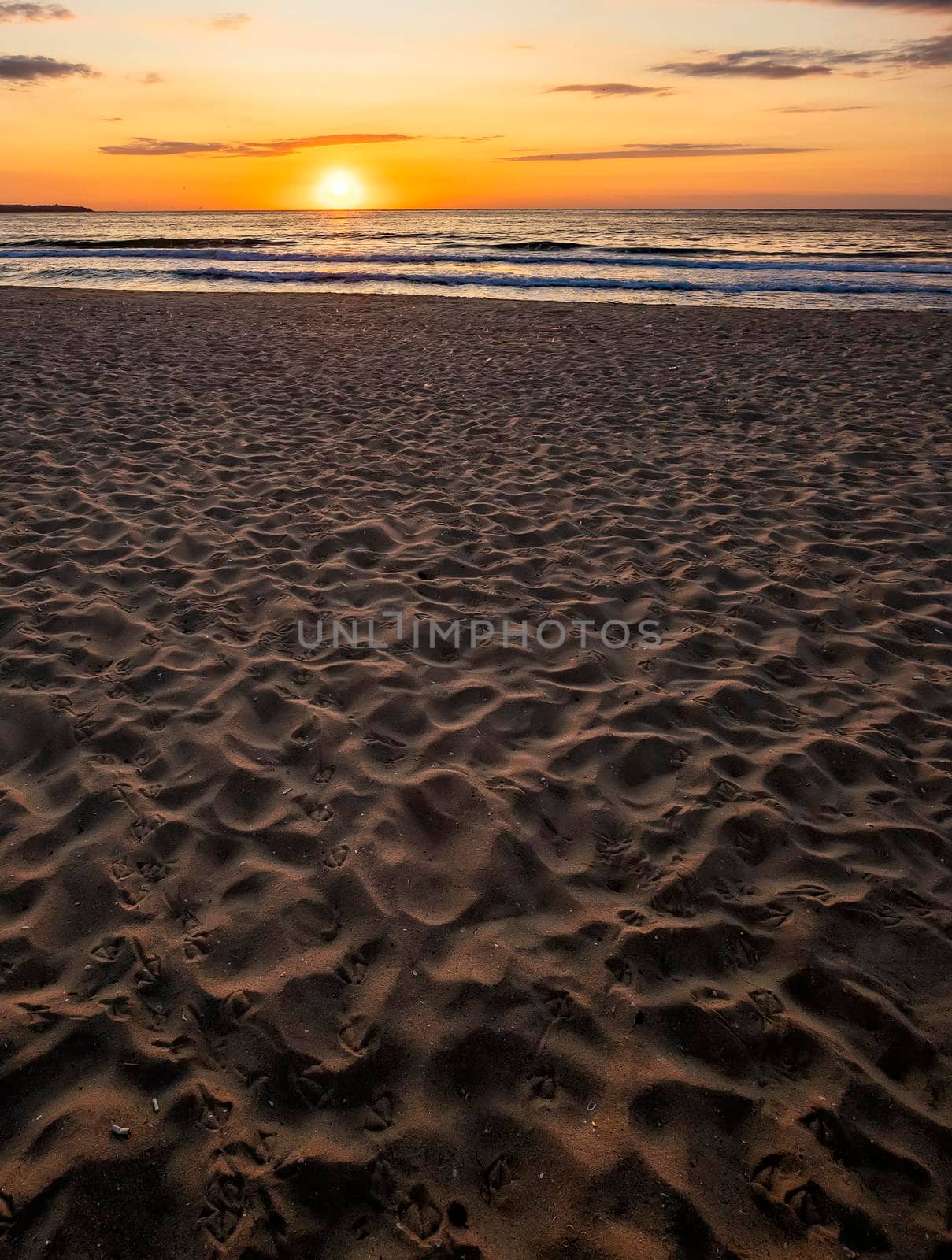 Beautiful sea sunset or sunrise over the sea from the sand. Vertical view