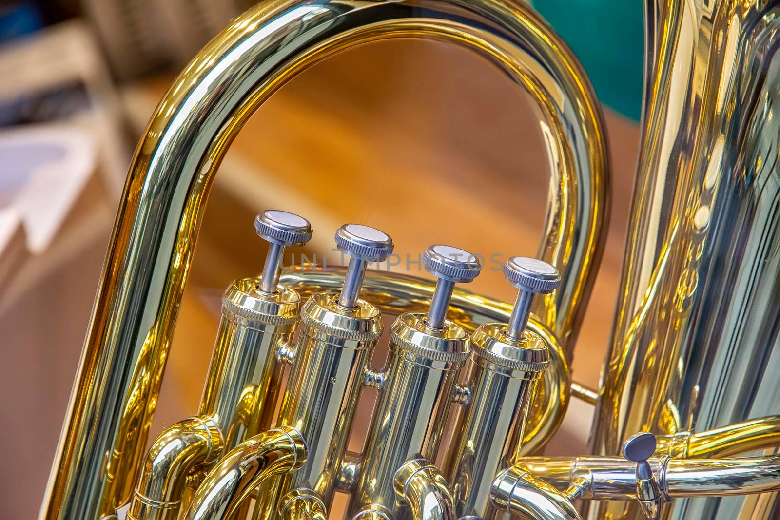 A part of the classical wind instrument with brass details. Close up of trumpet finger buttons valves