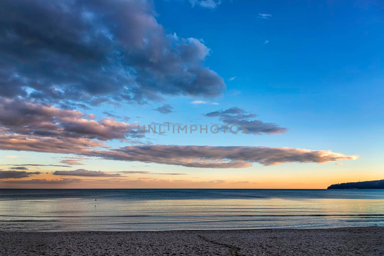 Beautiful colorful clouds over the sea. Amazing sky after sunset.