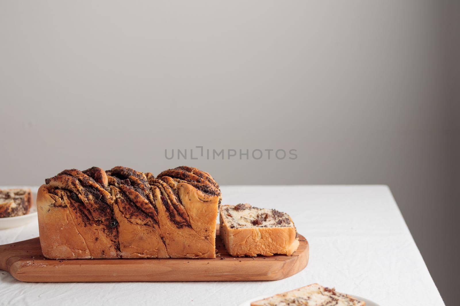 Sweet swirl homemade bread with poppy seeds on a white table