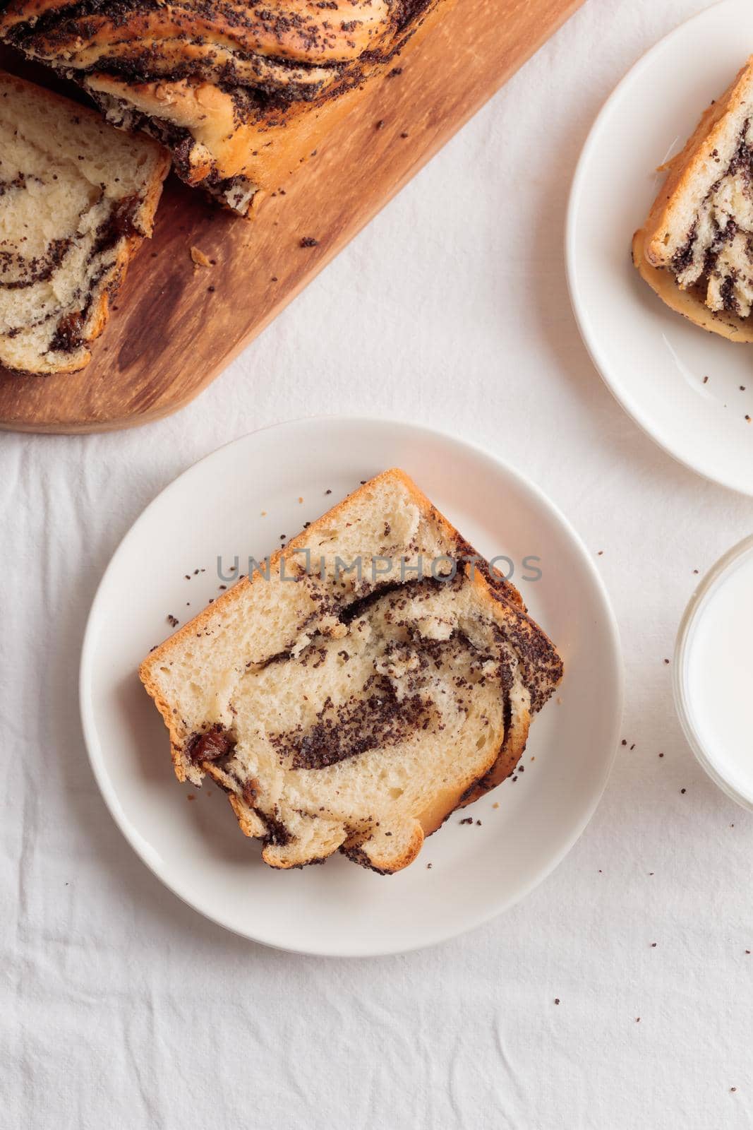 Sweet swirl homemade bread with poppy seeds on a white table