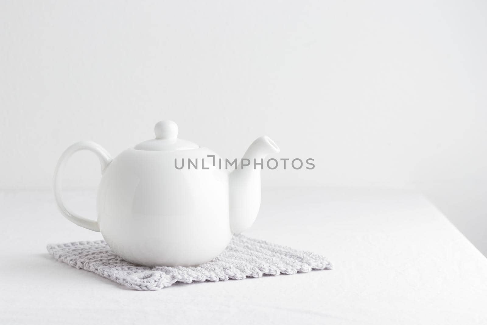 White teapot on a table on a white background