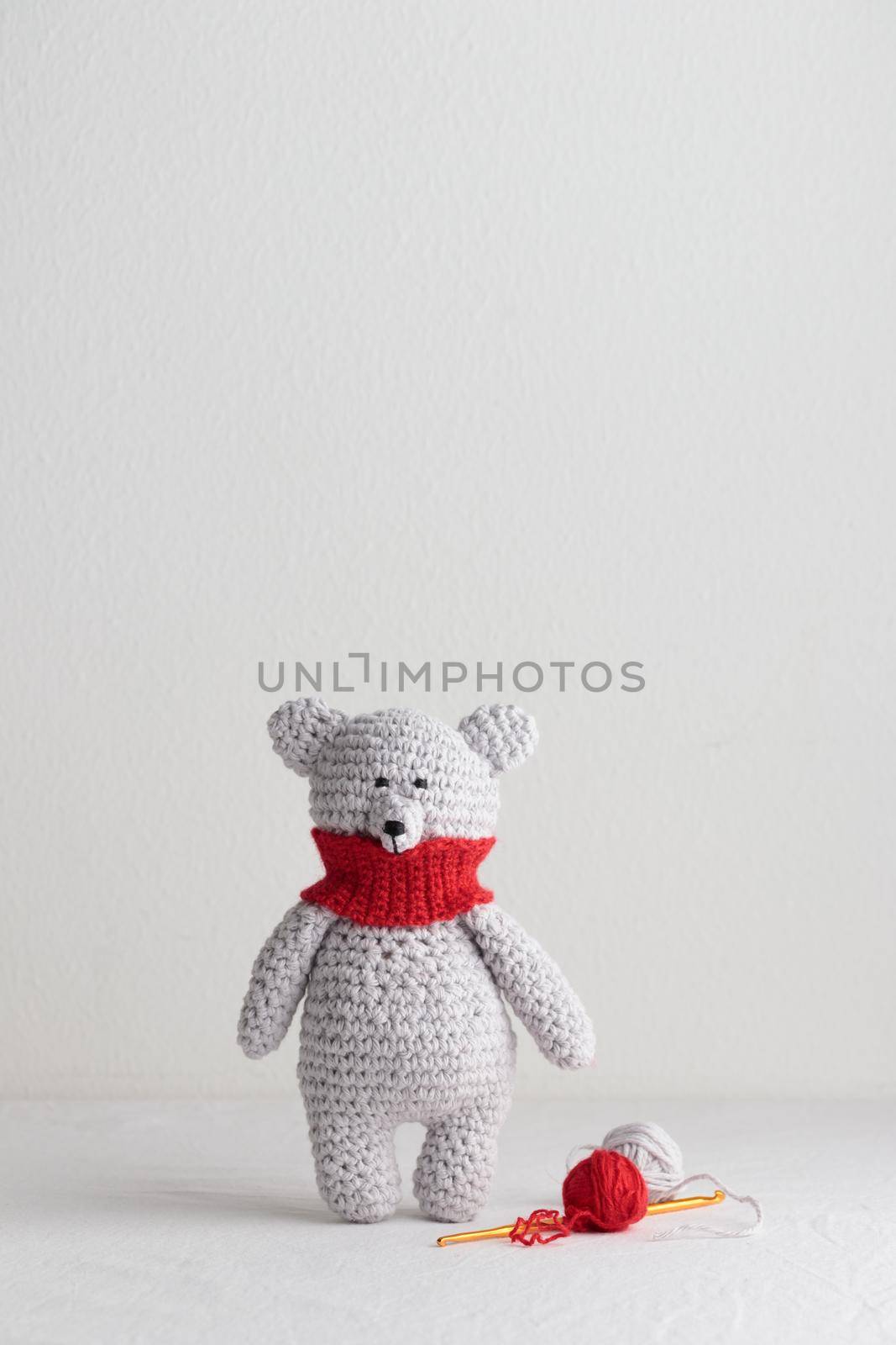Crochet knitting cute teddy bear with a red scarf