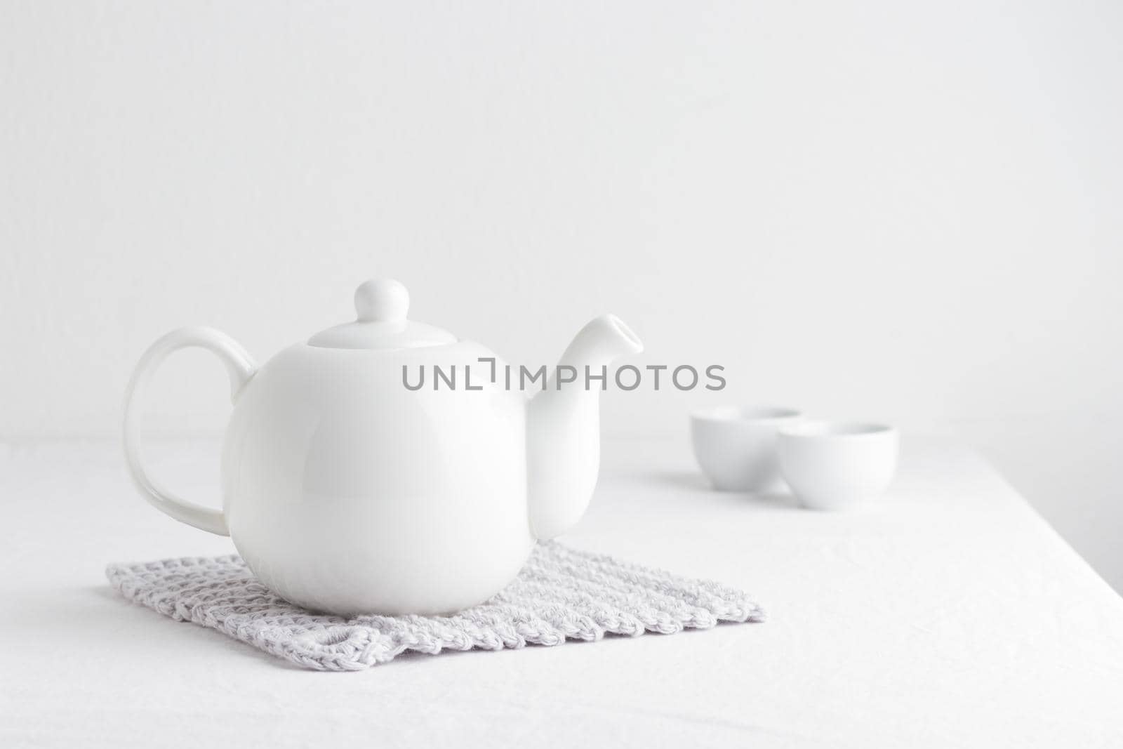 White teapot on a table on a white background