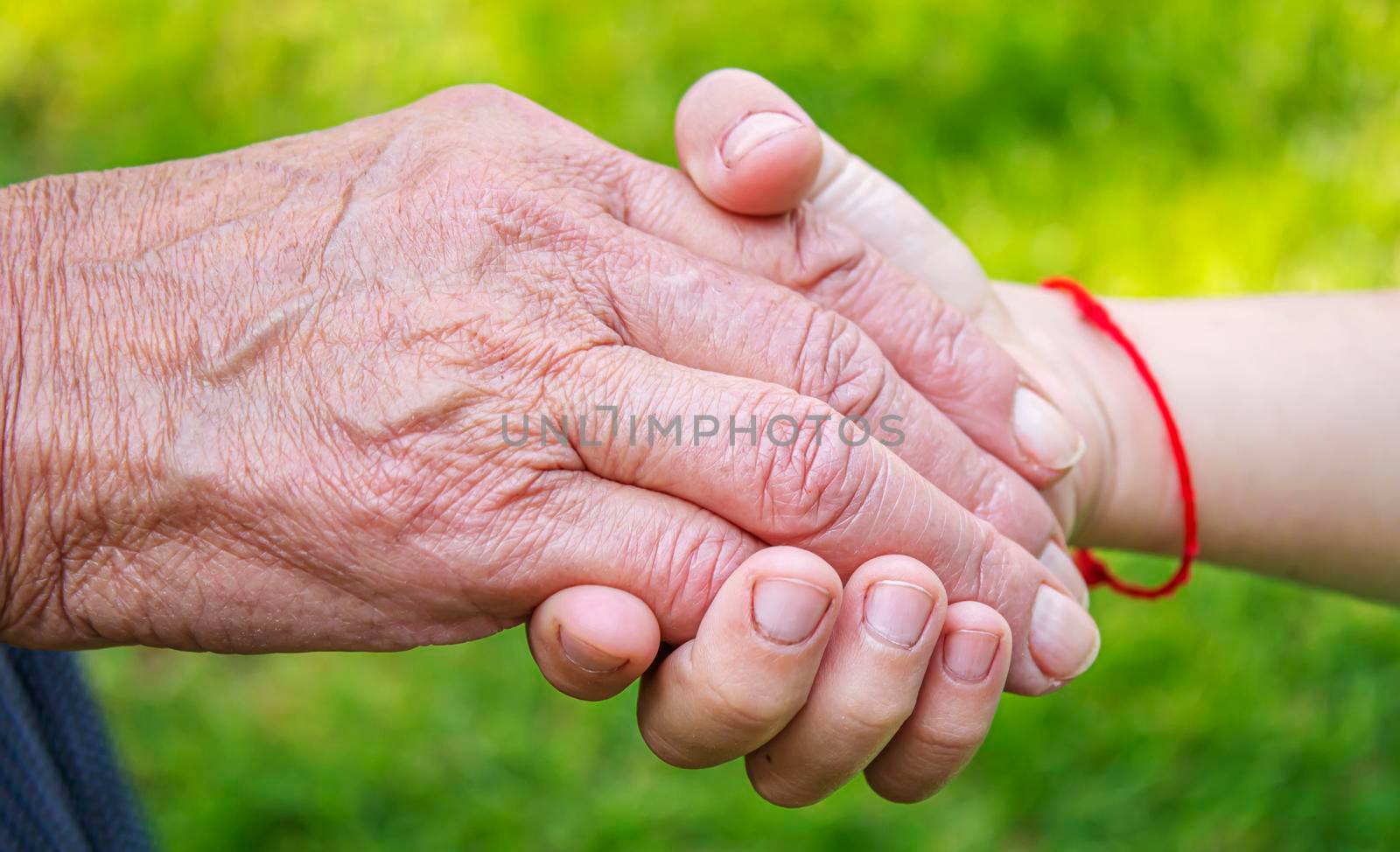 old man holding child's hands. selective focus people