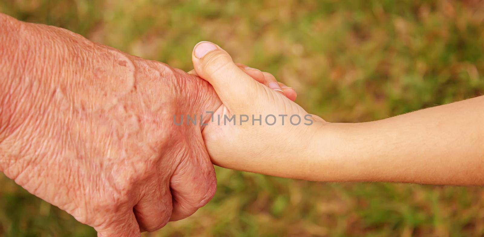 old man holding child's hands. selective focus.People