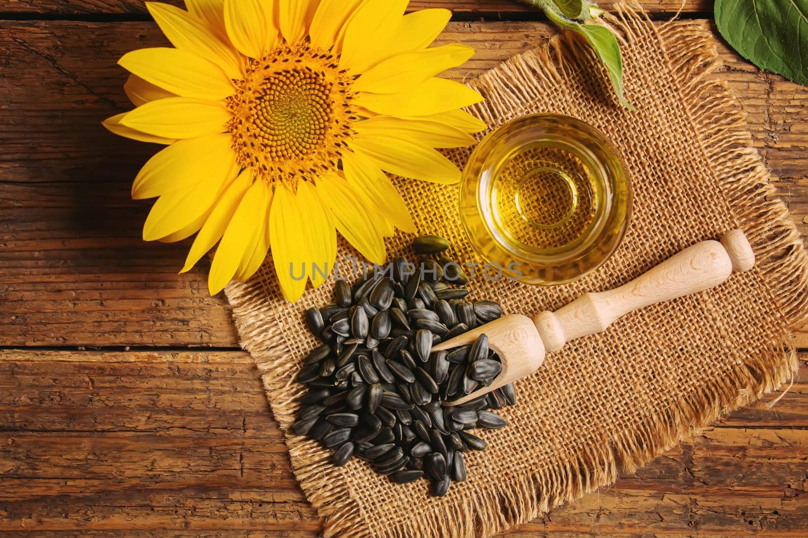 Sunflower seeds and oil bottle on old wooden background. Selective focus.nature