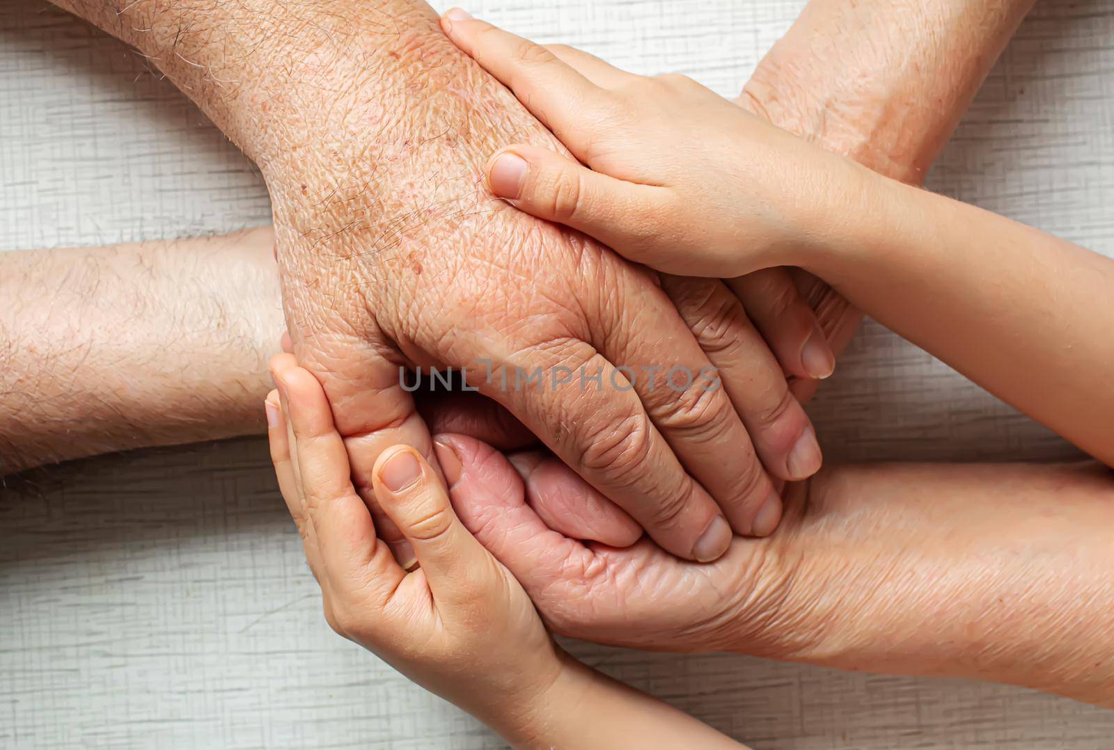 old man holding child's hands. selective focus people