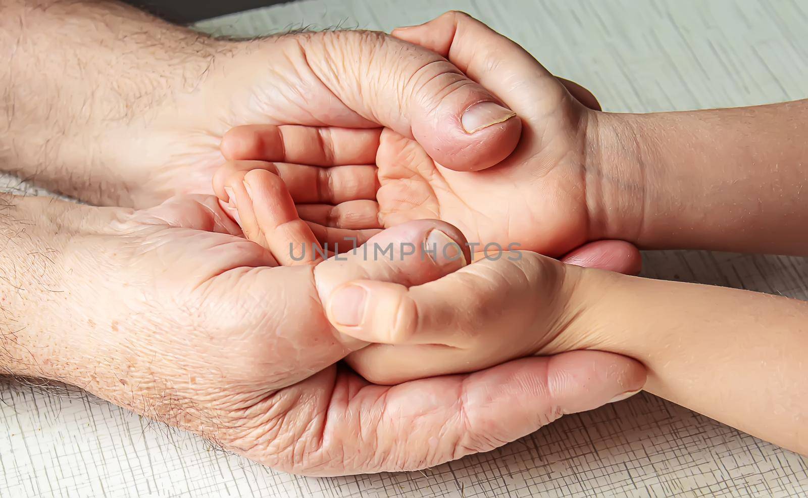 old man holding child's hands. selective focus people