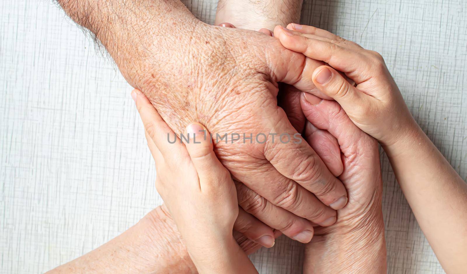 old man holding child's hands. selective focus people