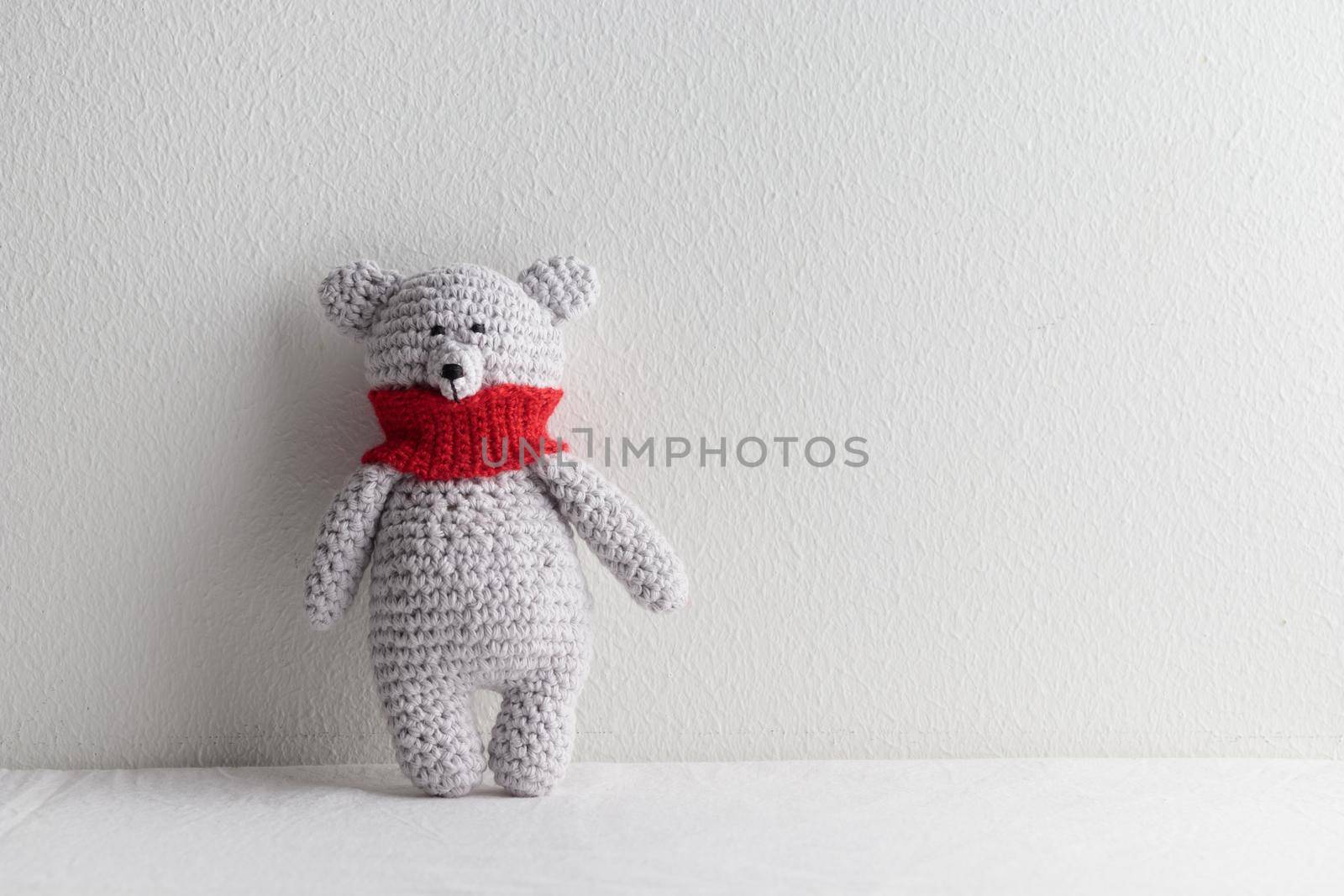 Crochet knitting cute teddy bear with a red scarf
