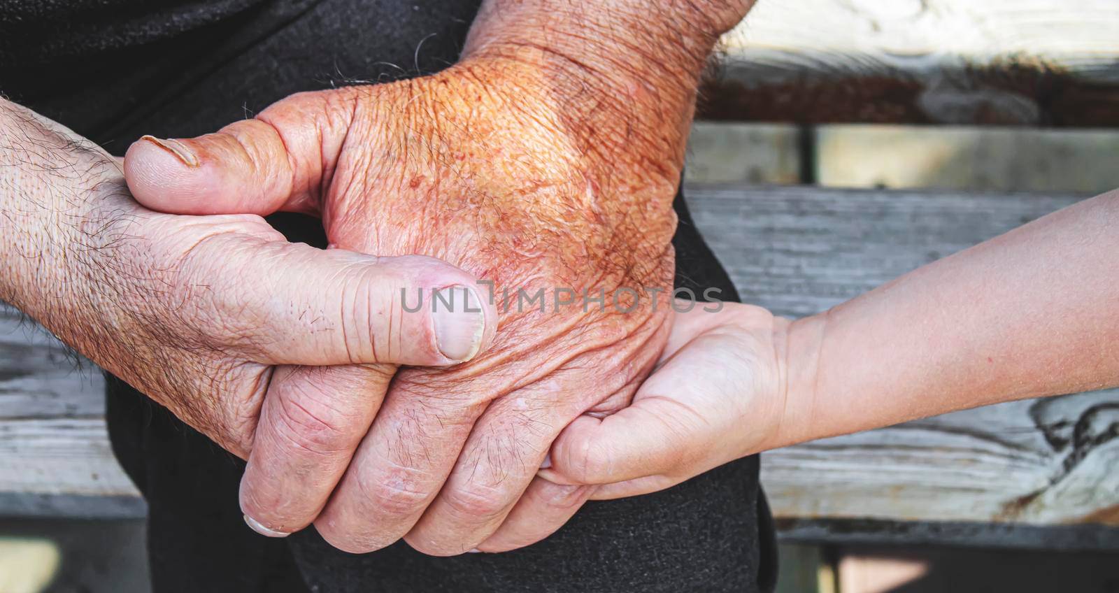 old man holding child's hands. selective focus people