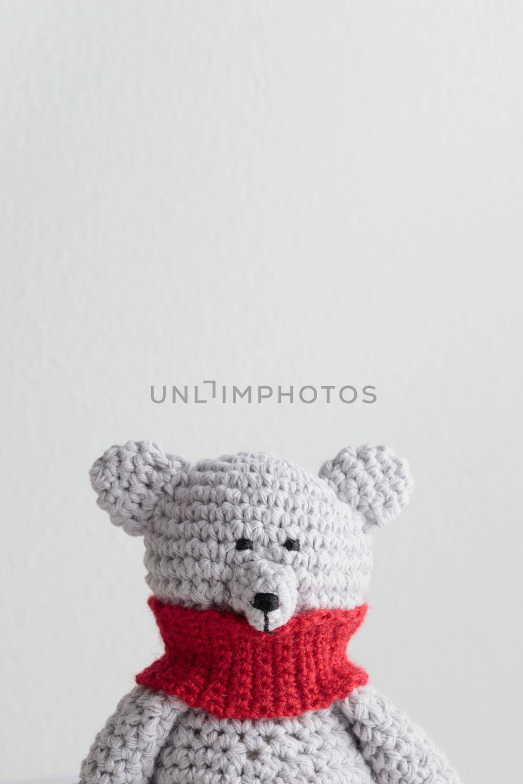 Crochet knitting cute teddy bear with a red scarf