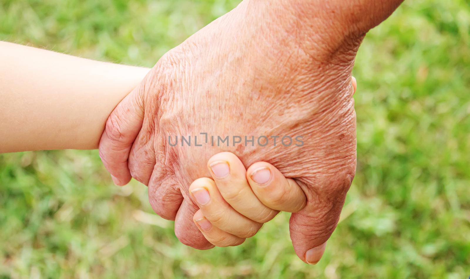 old man holding child's hands. selective focus.People