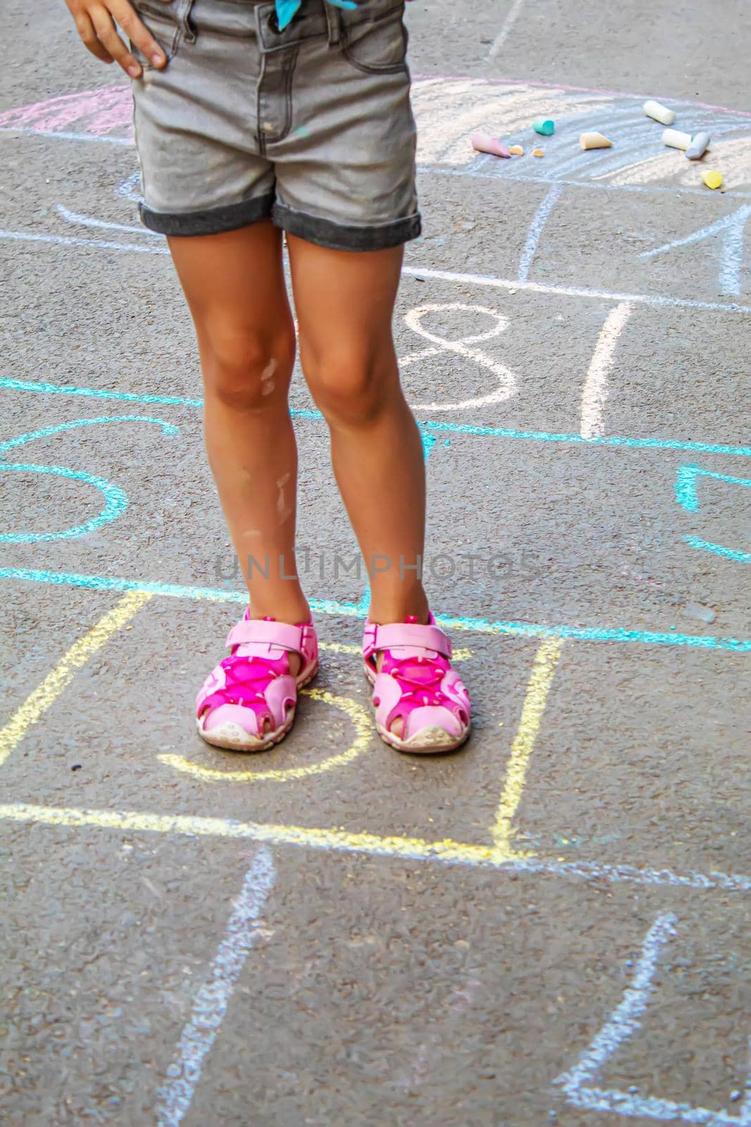 Child jumping classics on the pavement. Selective focus.child