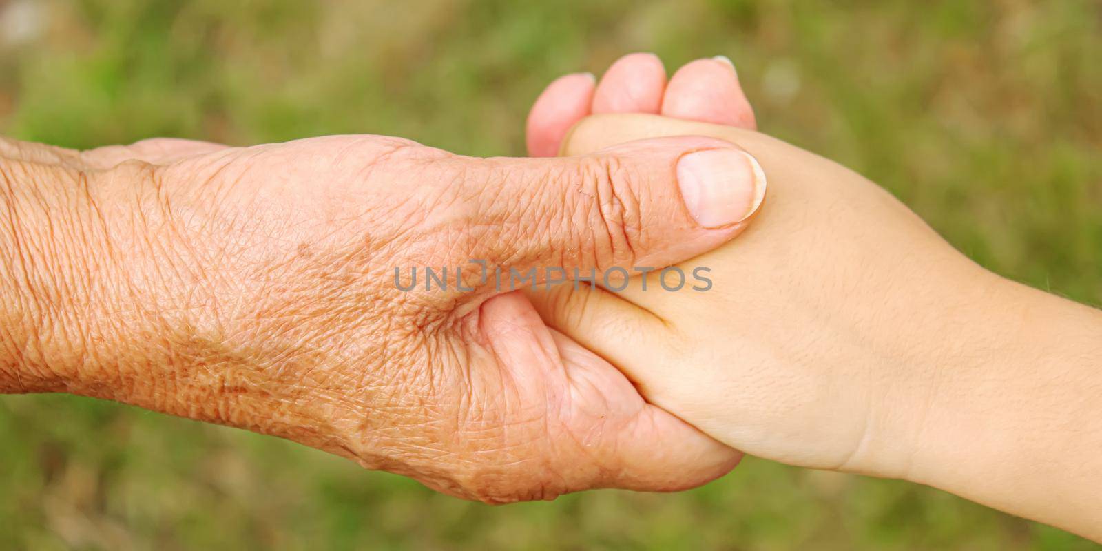 old man holding child's hands. selective focus by mila1784