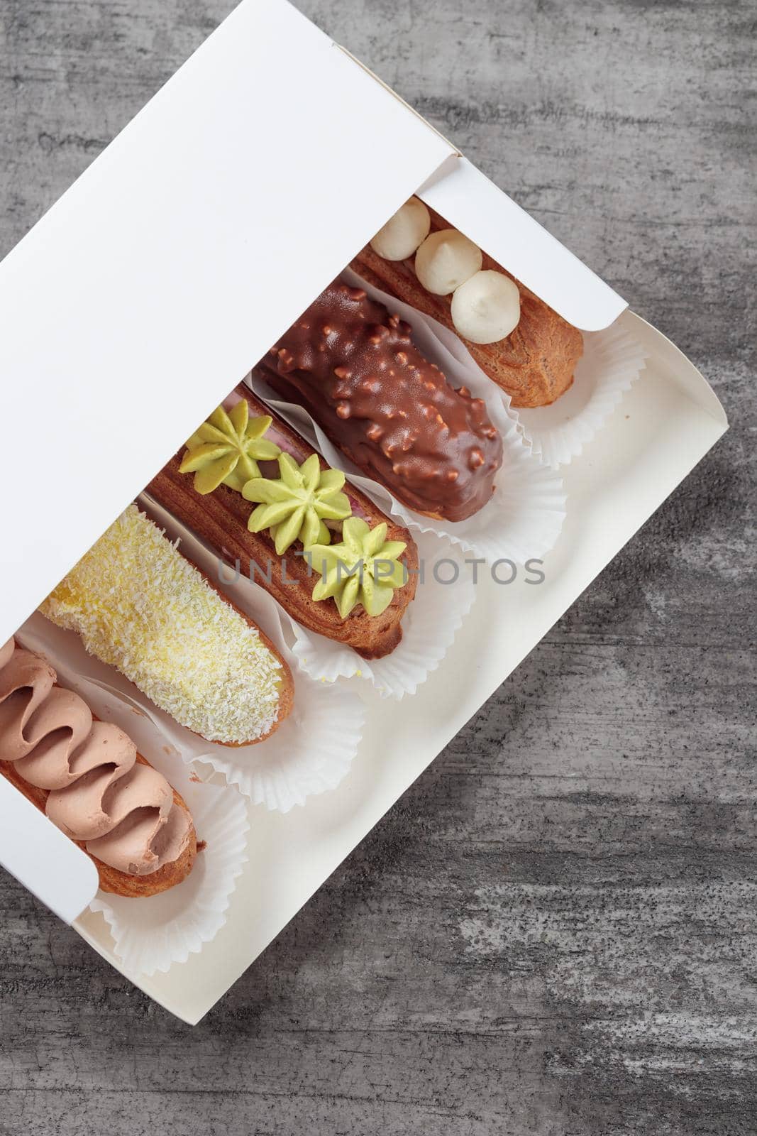 Set of French dessert sweet eclairs on a gray background