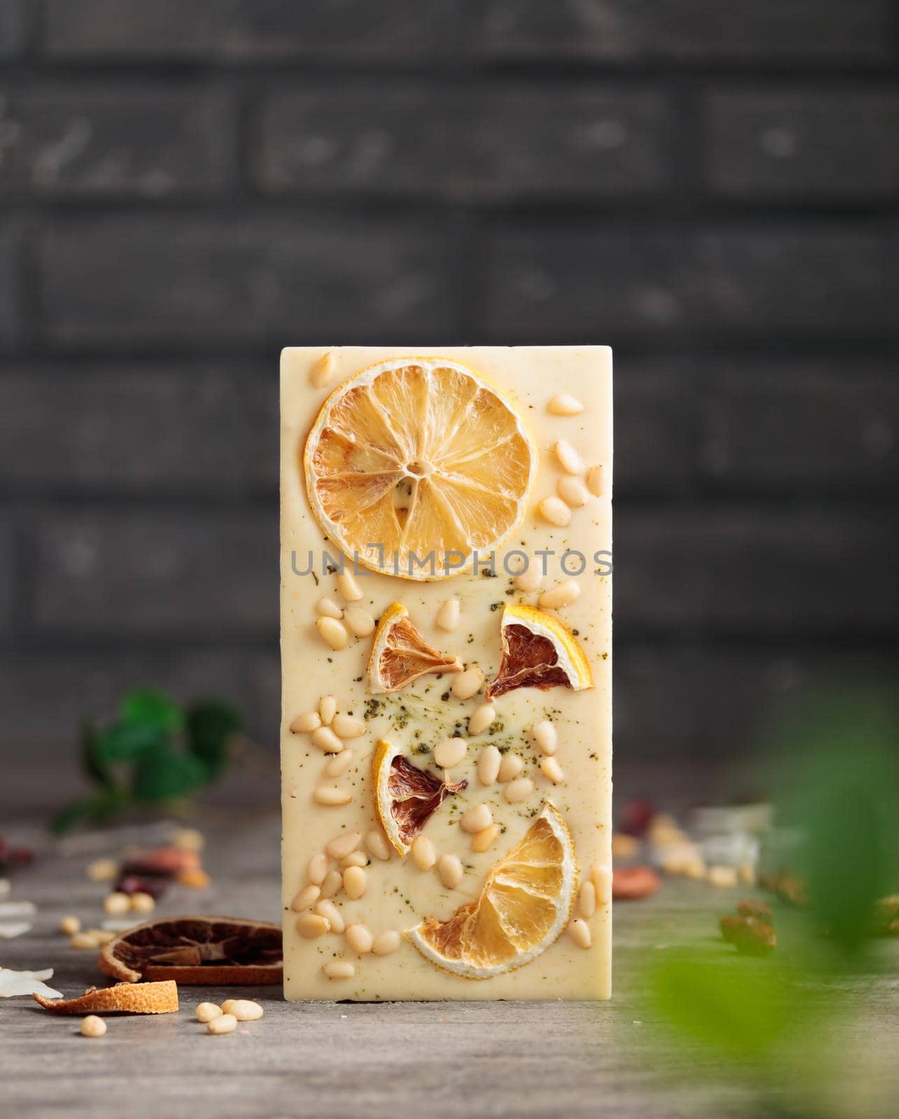 Craft chocolate with fruits and nuts on a gray background