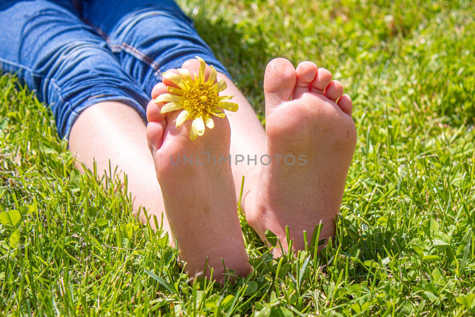 Child lying on green grass. Kid having fun outdoors in spring park. Selective focus. people