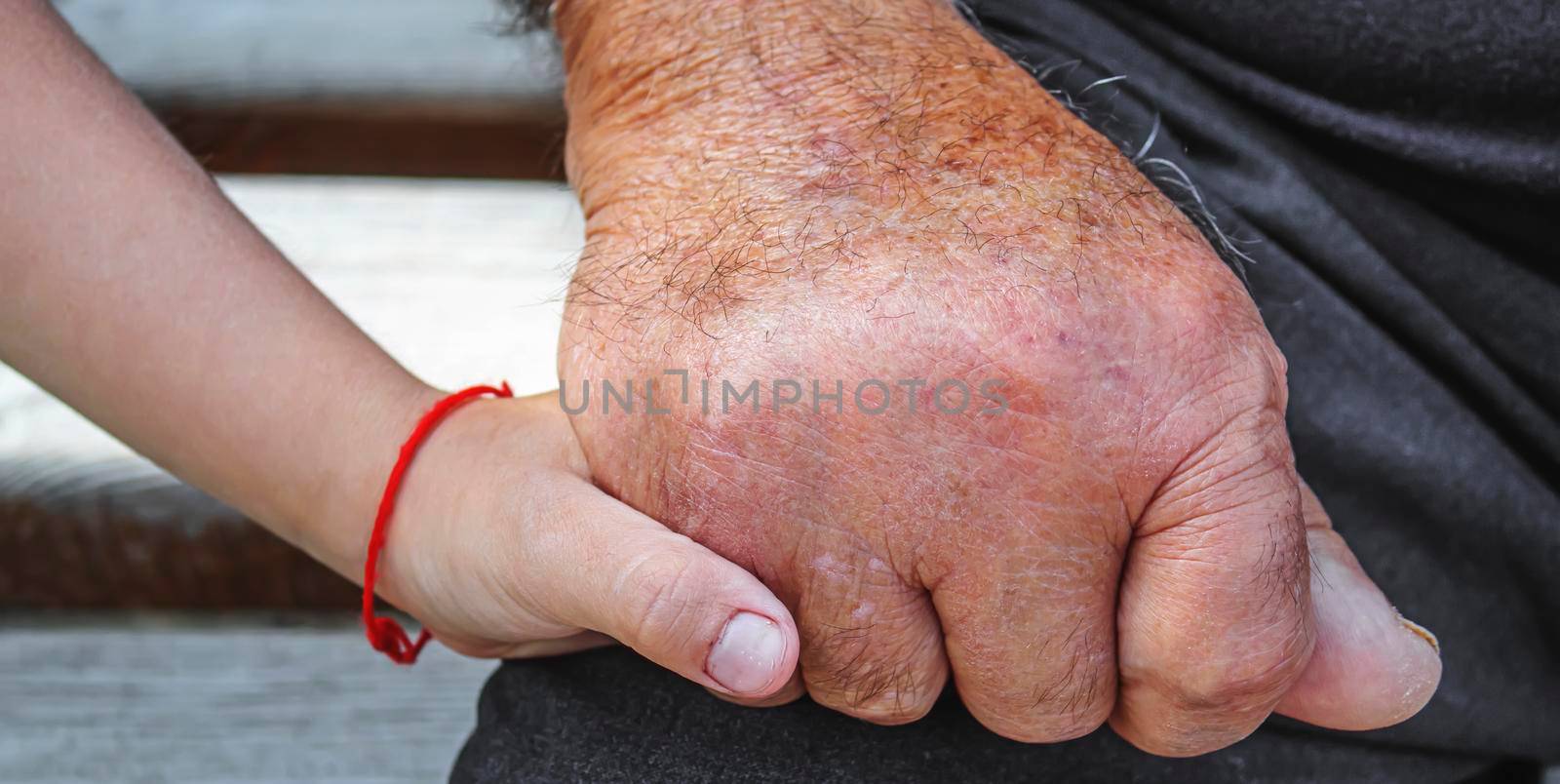 old man holding child's hands. selective focus people