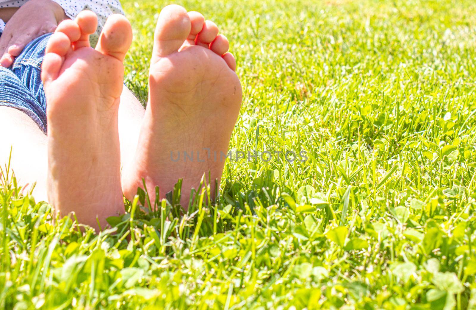 Child lying on green grass. Kid having fun outdoors in spring park. Selective focus. people