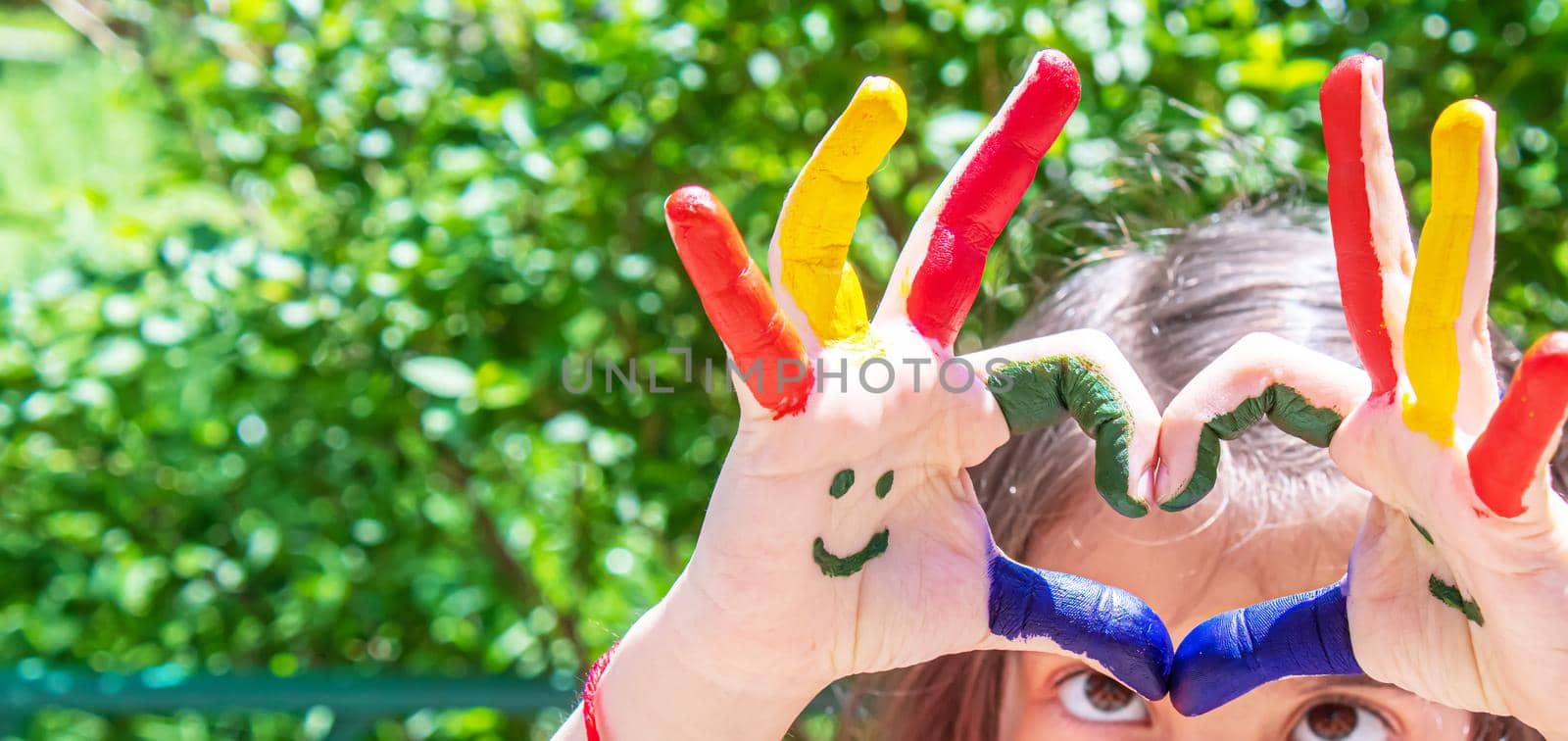 Children's hands in the colors of summer. Selective focus.nature