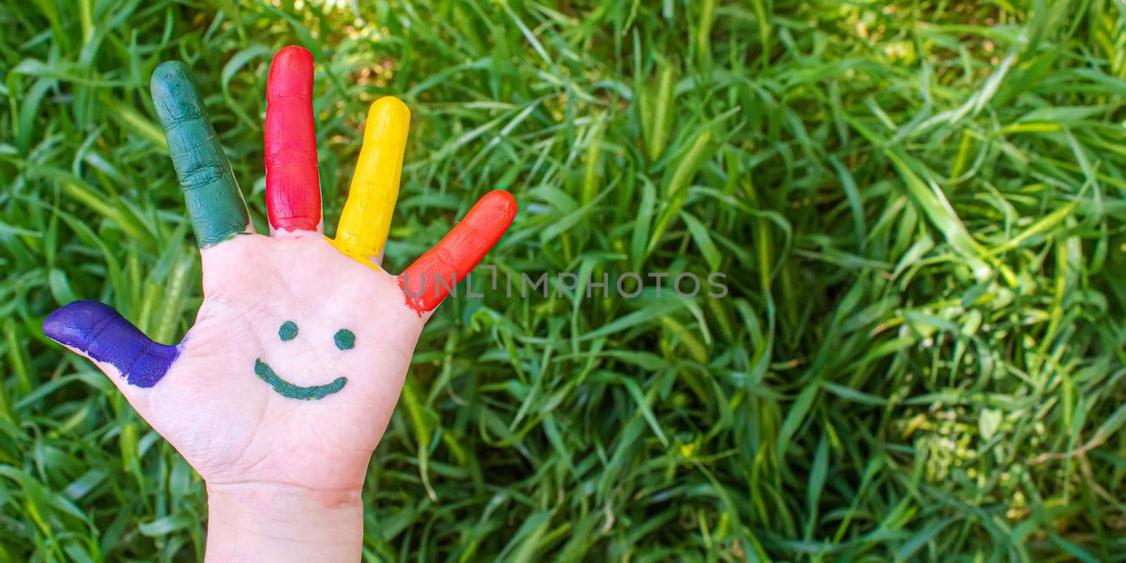 Children's hands in the colors of summer. Selective focus.nature