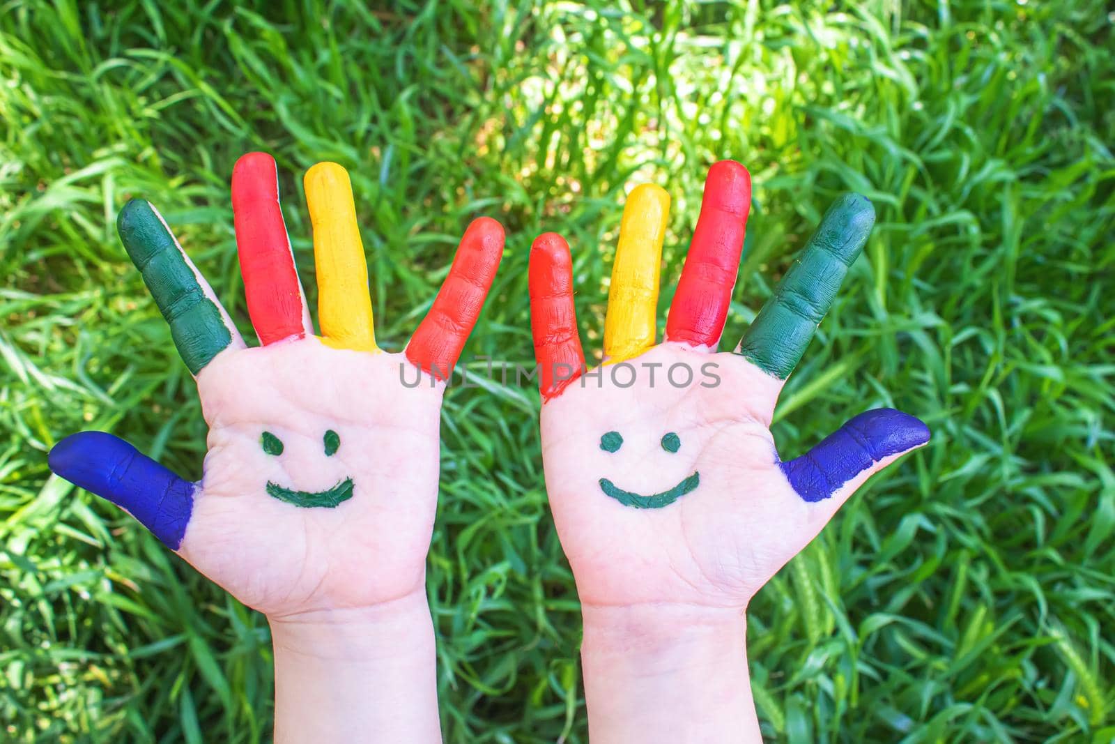 Children's hands in the colors of summer. Selective focus.nature