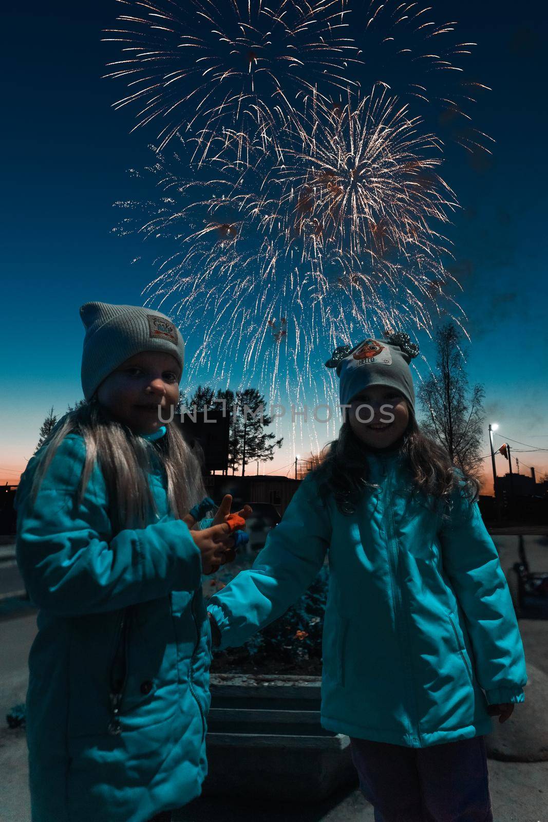 little girls in the dark on fireworks in warm jackets by krol666