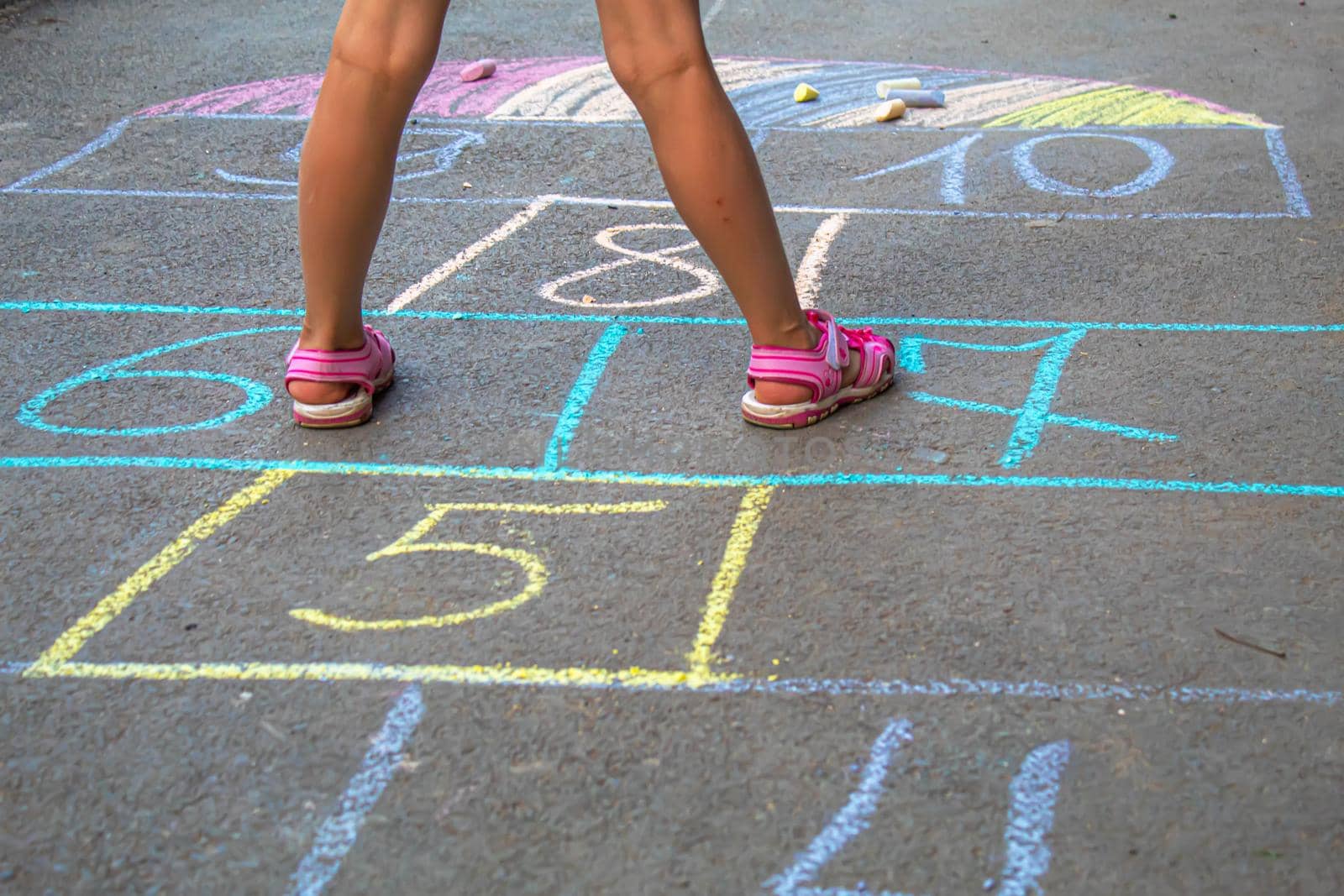 Child jumping classics on the pavement. Selective focus.child