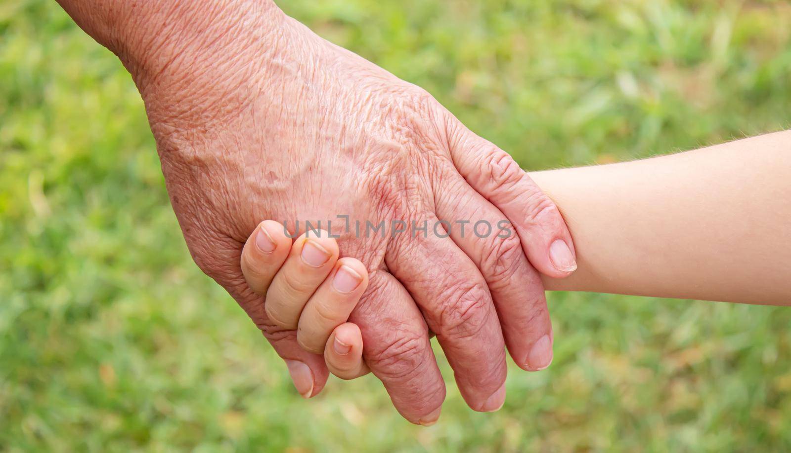 old man holding child's hands. selective focus.People