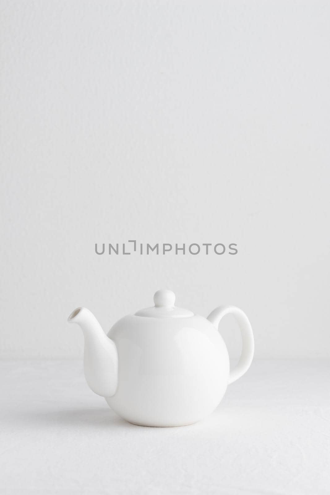 White teapot on a table on a white background